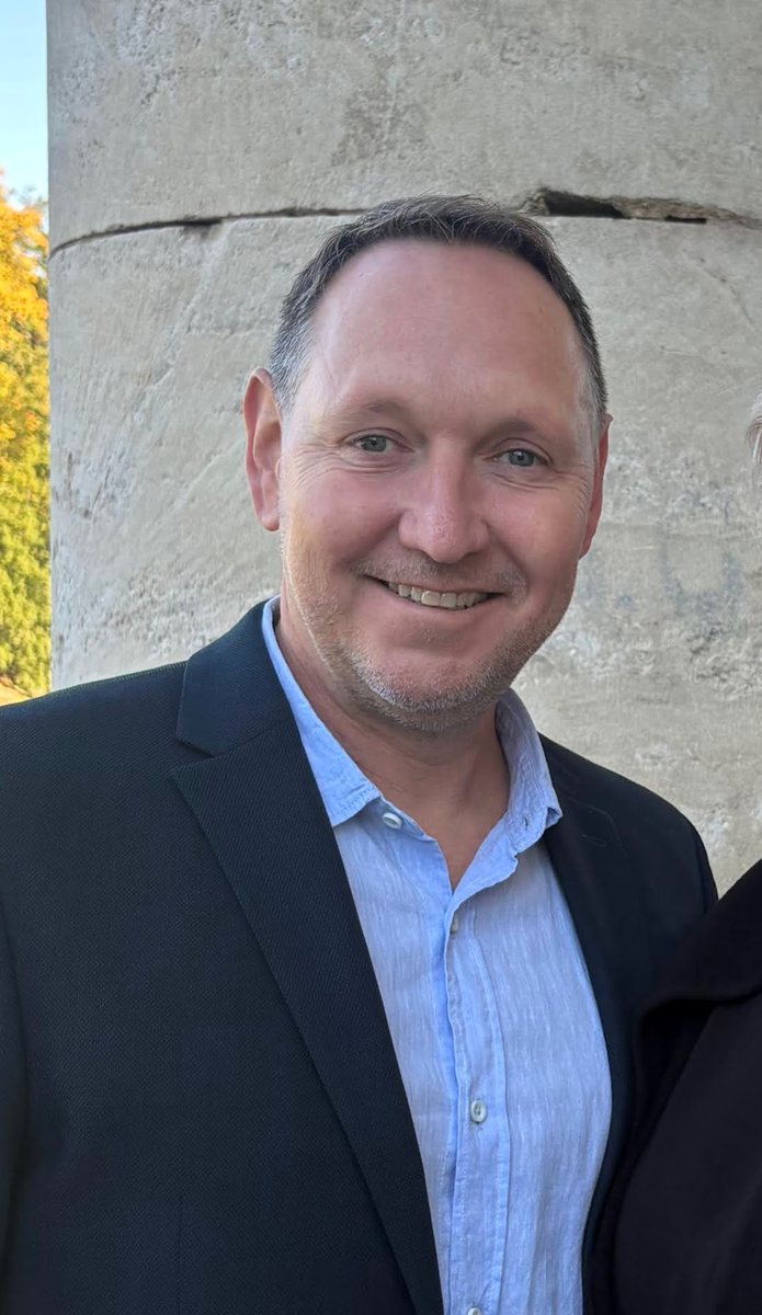 Arno Schalek im Business-Outfit vor einer Parkanlage